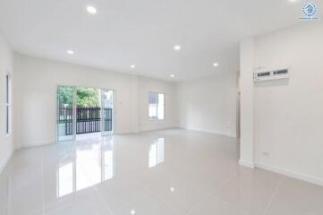 Spacious and well-lit living area with large windows and tiled flooring