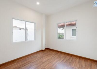 Empty bedroom with wooden floor and large windows