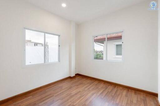 Empty bedroom with wooden floor and large windows