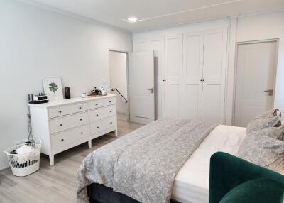 Bedroom with large bed, dresser, and closet