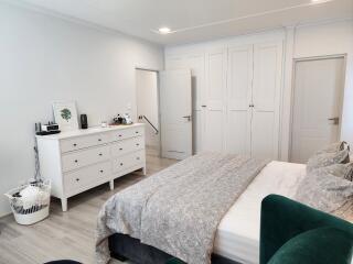 Bedroom with large bed, dresser, and closet