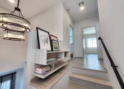 Modern stairway with bookshelves and decor leading to a bright room