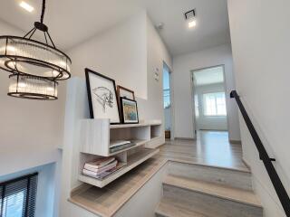 Modern stairway with bookshelves and decor leading to a bright room