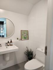 Modern bathroom view with sink, mirror, and toilet