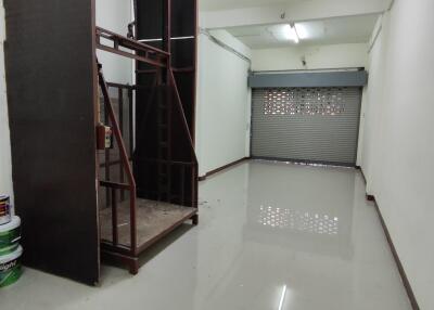 Interior view of a garage with a lift and roller shutter door