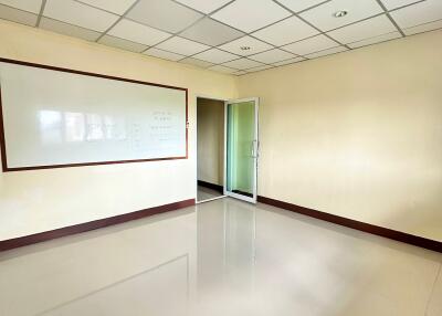 Empty office space with whiteboard and glass door