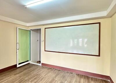 Empty room with wooden flooring and whiteboard