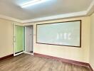 Empty room with wooden flooring and whiteboard