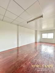 Empty room with wooden flooring and ceiling tiles