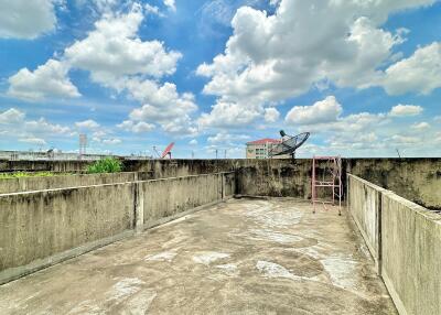 Rooftop terrace with clear blue sky and scattered clouds