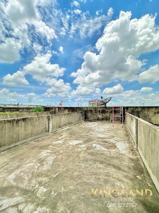 Rooftop terrace with clear blue sky and scattered clouds