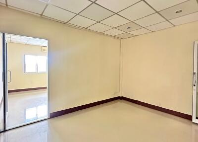 Empty room with tiled ceiling and glass door