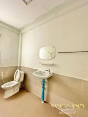 Modern bathroom with toilet, sink, mirror, and towel rack