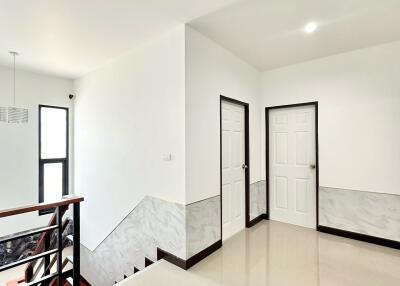 Bright hallway with white doors and stairs