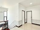 Bright hallway with white doors and stairs