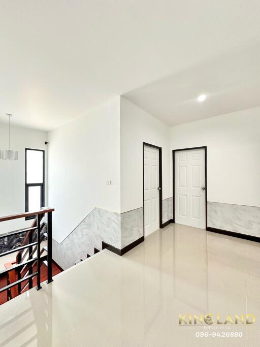 Bright hallway with white doors and stairs