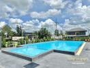 Swimming pool area with buildings in the background and clear skies