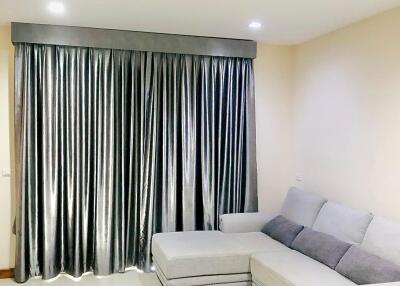 Living room with a grey sectional sofa and large grey curtains