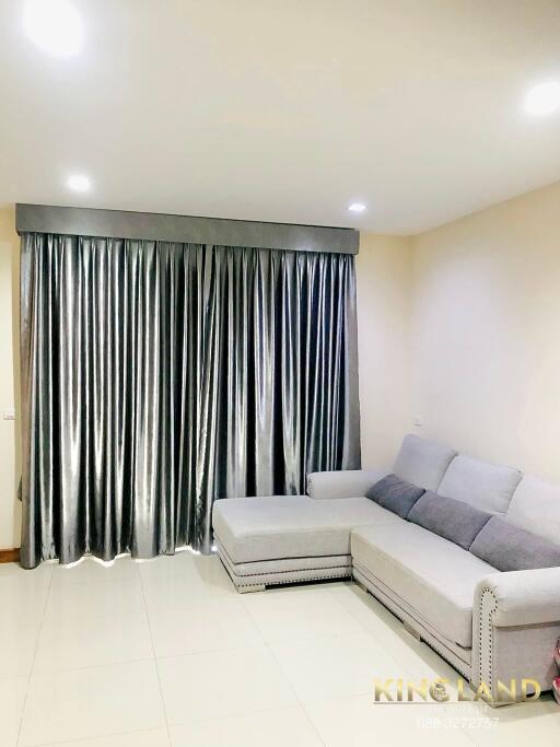 Living room with a grey sectional sofa and large grey curtains