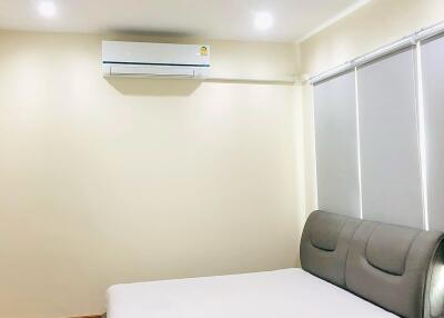 Modern furnished bedroom with bed and air conditioner