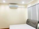 Modern furnished bedroom with bed and air conditioner