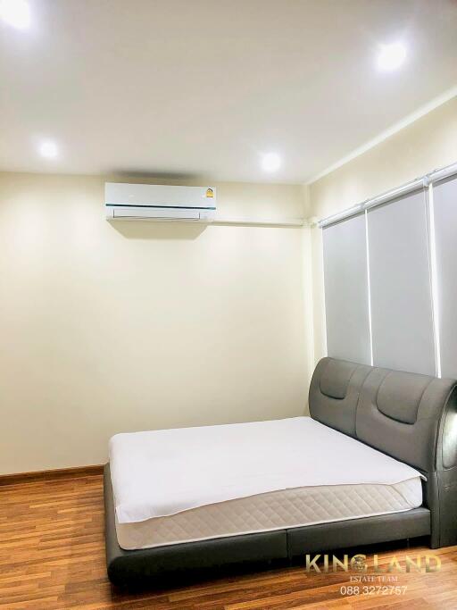 Modern furnished bedroom with bed and air conditioner