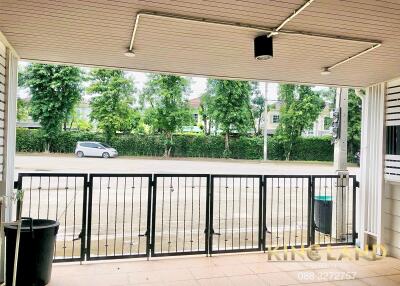 Covered outdoor patio with view of the street and greenery