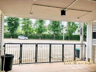 Covered outdoor patio with view of the street and greenery