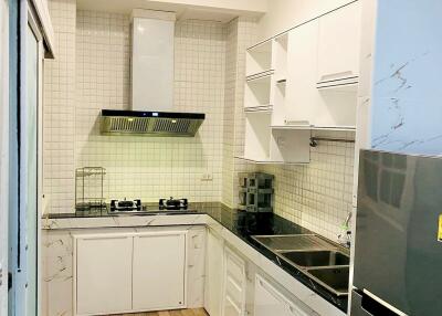 Modern kitchen with tiled backsplash and wooden flooring