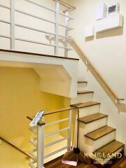 Indoor staircase area with wooden steps and white railings