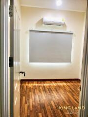 Bright bedroom with wooden flooring and air conditioning