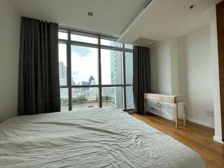 Modern bedroom with large windows and a city view