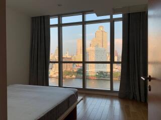 Bedroom with a large window offering a cityscape view