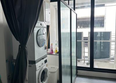 Utility area with stacked washer and dryer near balcony