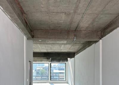 Interior view of building under construction with concrete ceiling and large windows