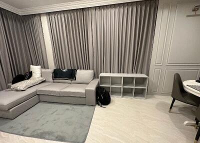 Living room with gray sectional sofa and curtain