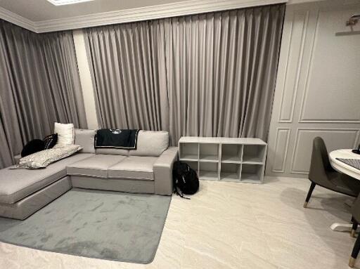 Living room with gray sectional sofa and curtain