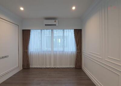 Modern living room with wooden flooring and large window