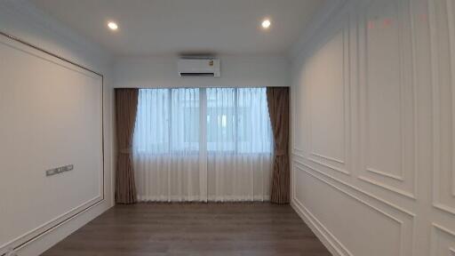 Modern living room with wooden flooring and large window