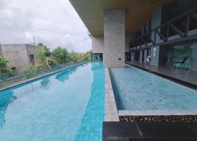 Outdoor swimming pool with adjacent building and seating area