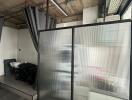 Industrial-style studio space with frosted glass divider