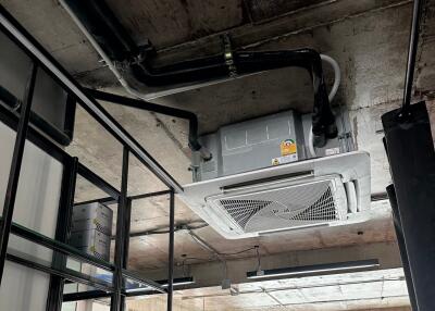 Ceiling with exposed ductwork and air conditioning unit