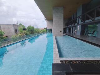 Swimming pool area with clear blue water and poolside seating