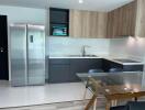 Modern kitchen with integrated appliances and glass dining table