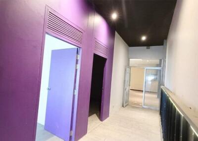 Hallway with purple doors and built-in lighting