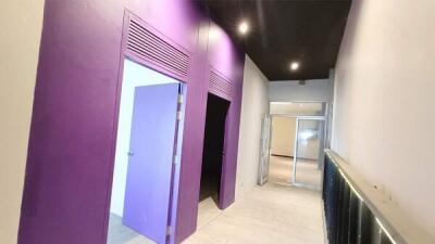 Hallway with purple doors and built-in lighting