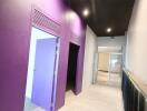 Hallway with purple doors and built-in lighting