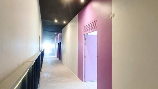 Brightly lit corridor with purple and white walls