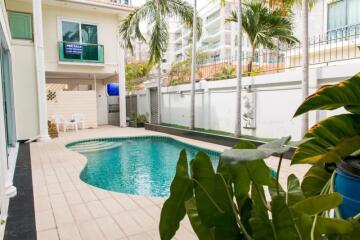 Outdoor pool area with seating and garden