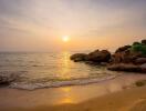 Sunset at the beach with rocks and calm waves